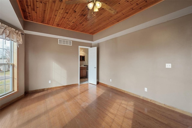 empty room with plenty of natural light, ceiling fan, light wood-type flooring, and wooden ceiling