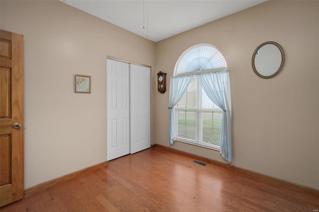 unfurnished bedroom featuring a closet and light wood-type flooring