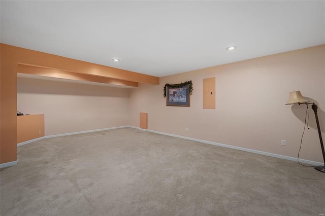 basement featuring light colored carpet and electric panel