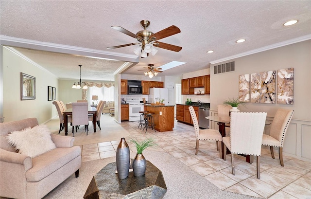 living room with ceiling fan with notable chandelier, a textured ceiling, sink, light tile patterned flooring, and crown molding