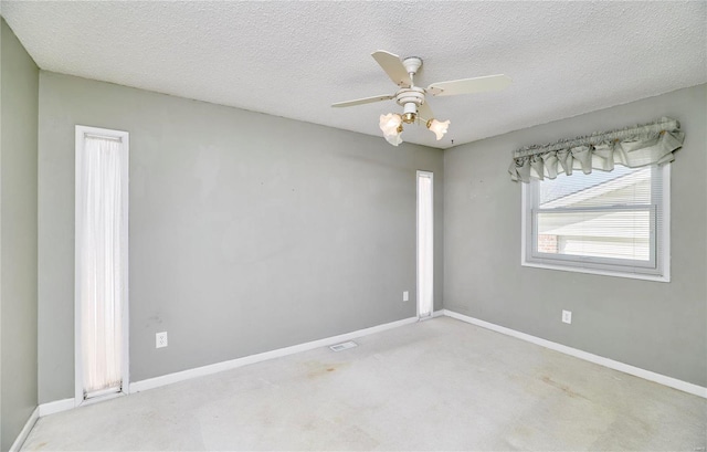 carpeted spare room with a textured ceiling and ceiling fan