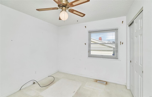 unfurnished room featuring ceiling fan and a textured ceiling