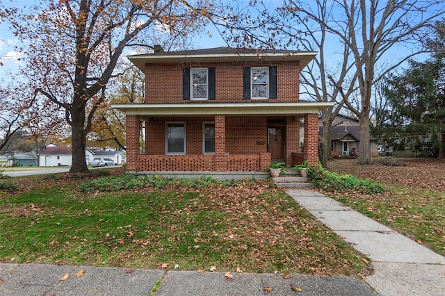 view of front facade with covered porch and a front yard