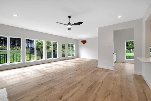 unfurnished living room with ceiling fan and light hardwood / wood-style floors