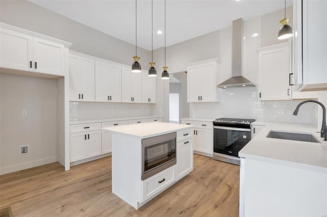 kitchen with built in microwave, wall chimney range hood, sink, electric stove, and white cabinetry