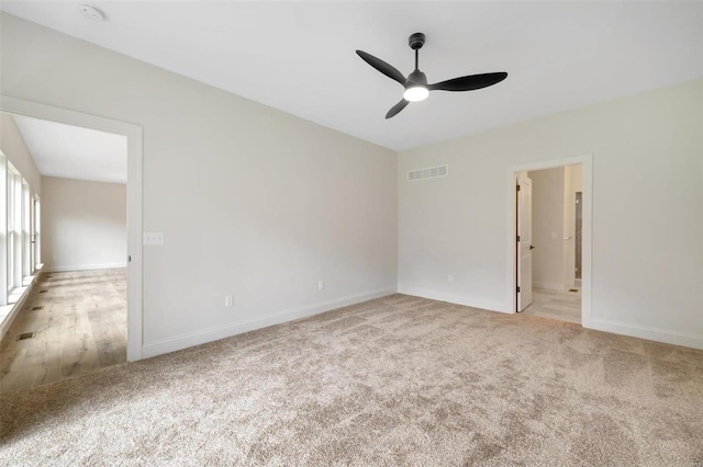 empty room with ceiling fan and light colored carpet