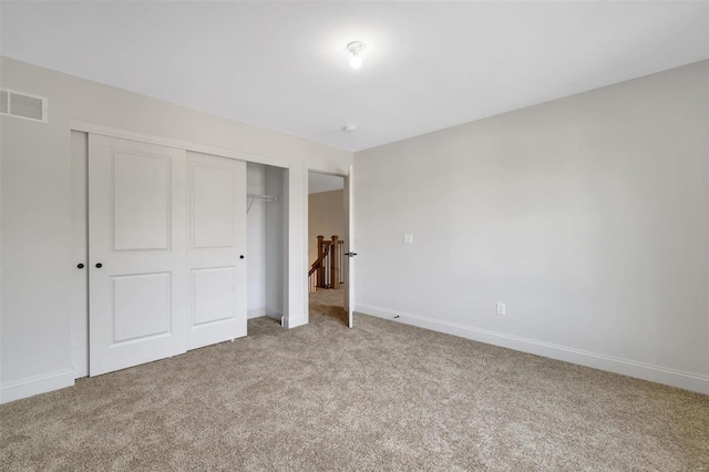 unfurnished bedroom featuring carpet flooring and a closet