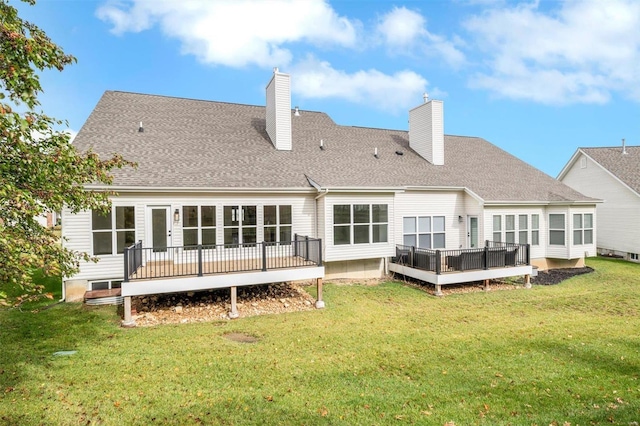 back of property featuring a lawn and a deck