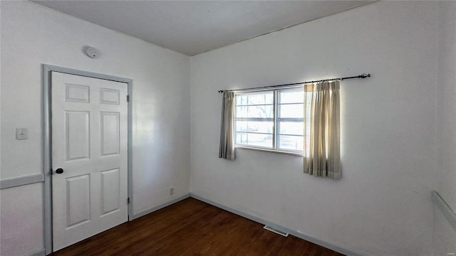 unfurnished room with dark hardwood / wood-style floors