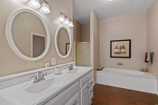 bathroom with vanity, wood-type flooring, and a tub