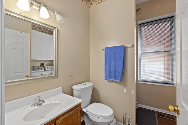 bathroom with vanity, toilet, and washing machine and dryer