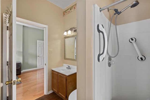 bathroom featuring hardwood / wood-style floors, vanity, and walk in shower