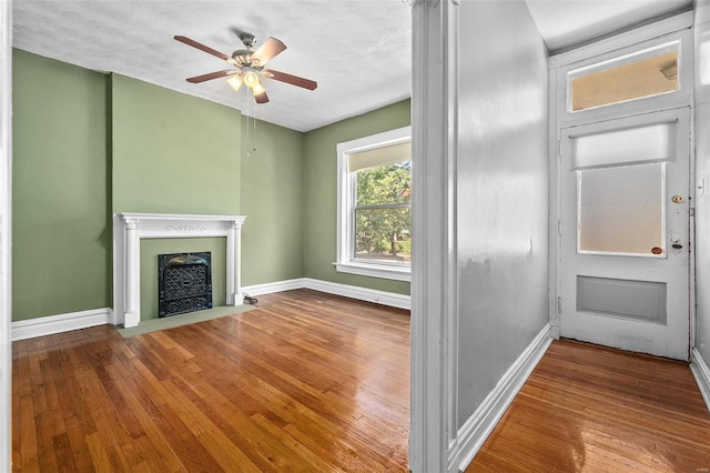 unfurnished living room with hardwood / wood-style floors, a textured ceiling, and ceiling fan