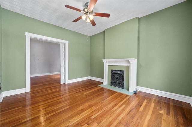 unfurnished living room with ceiling fan, a textured ceiling, and hardwood / wood-style flooring