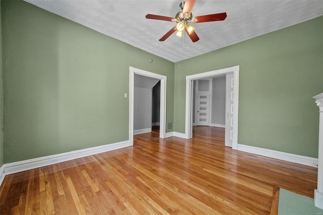 empty room with ceiling fan, light hardwood / wood-style floors, and a textured ceiling