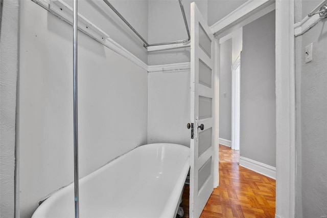 bathroom with a bathing tub and parquet flooring