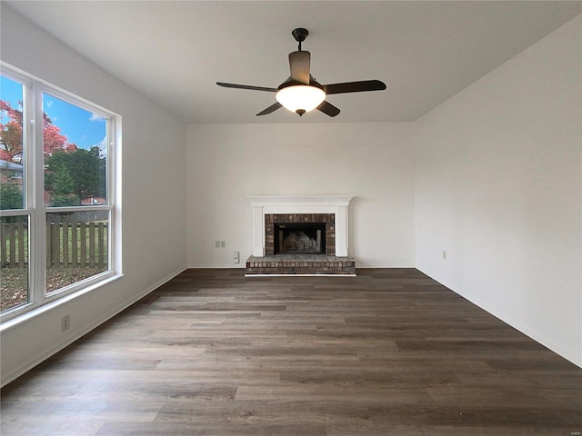 unfurnished living room featuring a fireplace, ceiling fan, and dark wood-type flooring