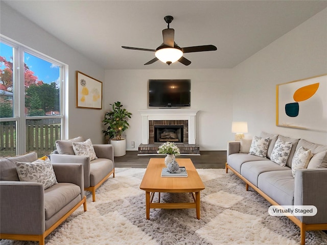 living room featuring hardwood / wood-style flooring, a brick fireplace, and ceiling fan