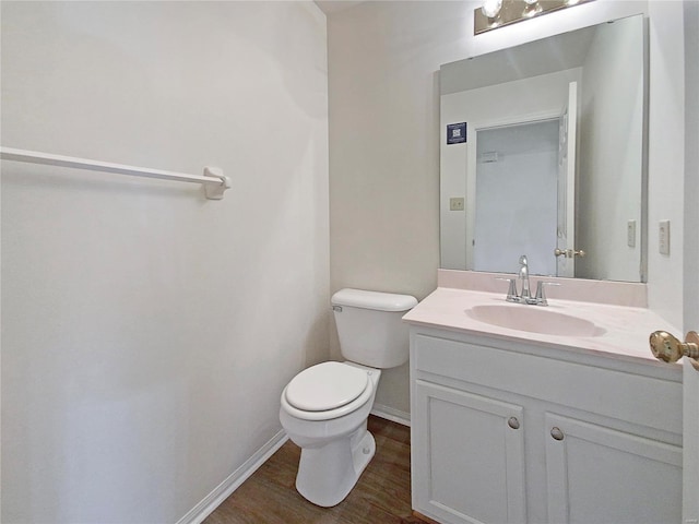 bathroom with hardwood / wood-style floors, vanity, and toilet