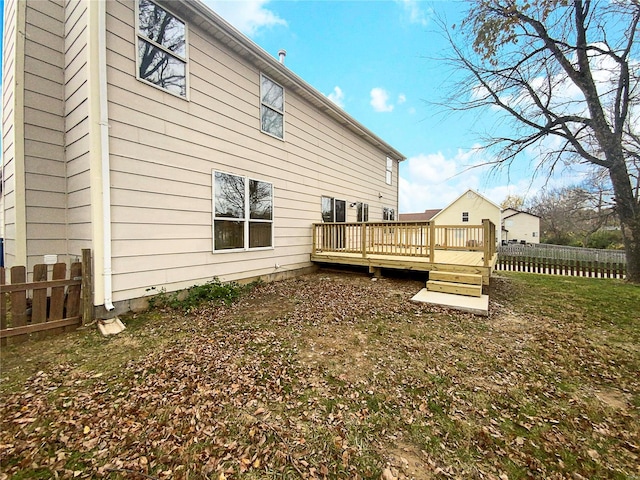 back of property featuring a lawn and a wooden deck