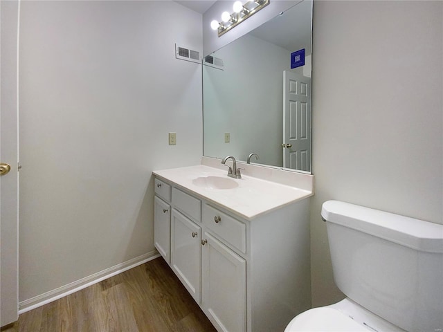 bathroom with wood-type flooring, vanity, and toilet