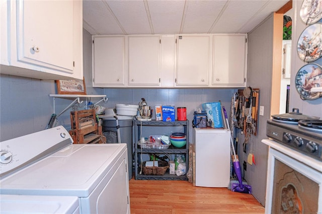 clothes washing area featuring light hardwood / wood-style flooring and washer and dryer