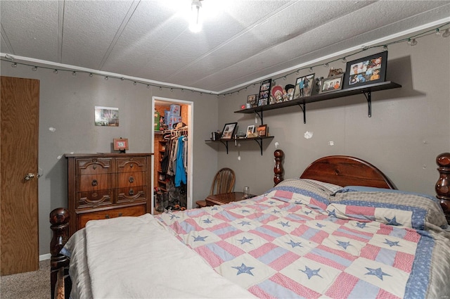 bedroom with a walk in closet, a closet, and carpet