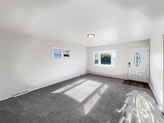 foyer entrance featuring dark carpet