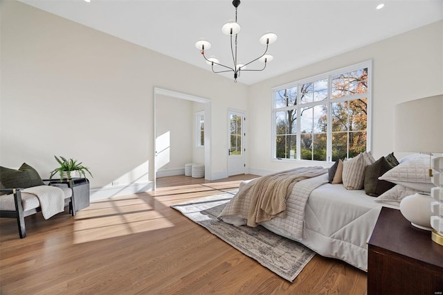 bedroom with wood-type flooring and an inviting chandelier