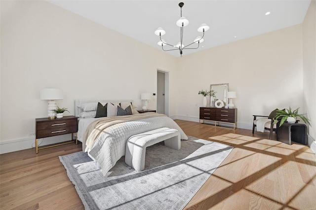 bedroom with a chandelier and light hardwood / wood-style floors