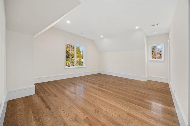 additional living space featuring lofted ceiling and light wood-type flooring