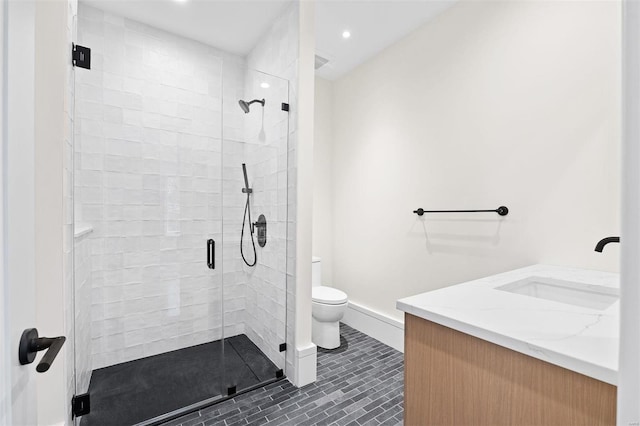 bathroom featuring vanity, a shower with shower door, tile patterned floors, and toilet