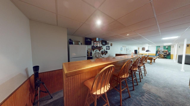 bar with carpet floors, a drop ceiling, and white fridge