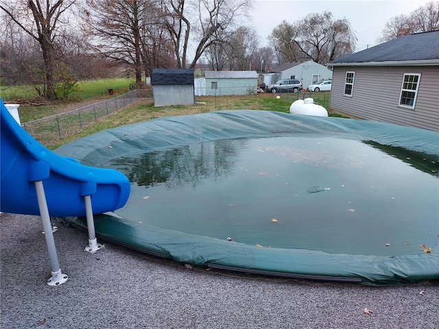 view of swimming pool with a water slide and a shed