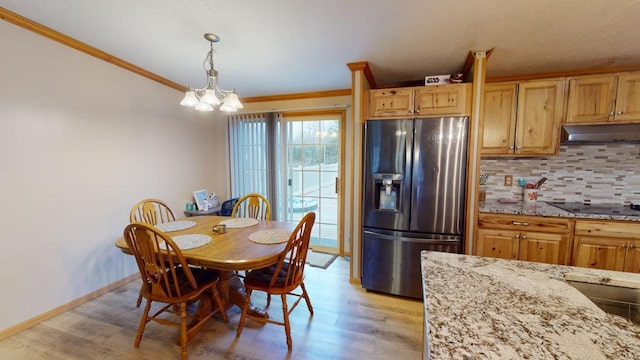 dining area featuring a notable chandelier, light hardwood / wood-style floors, and ornamental molding