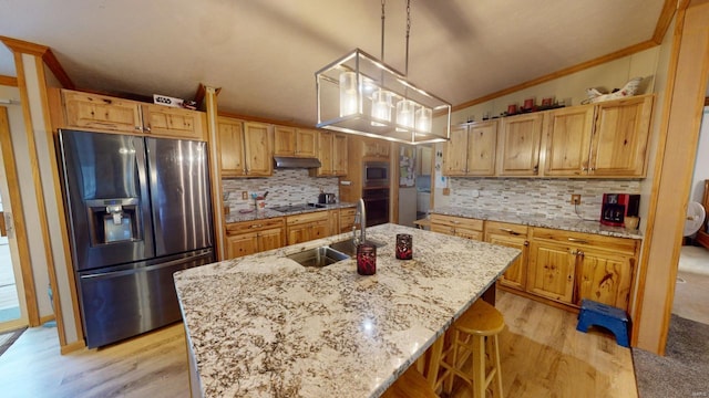 kitchen with sink, hanging light fixtures, lofted ceiling, a center island with sink, and black appliances