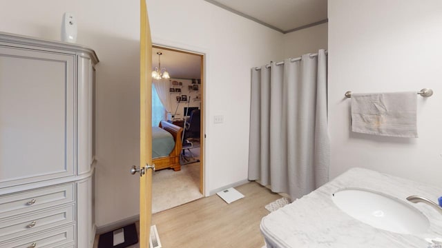 bathroom with vanity, wood-type flooring, and a chandelier