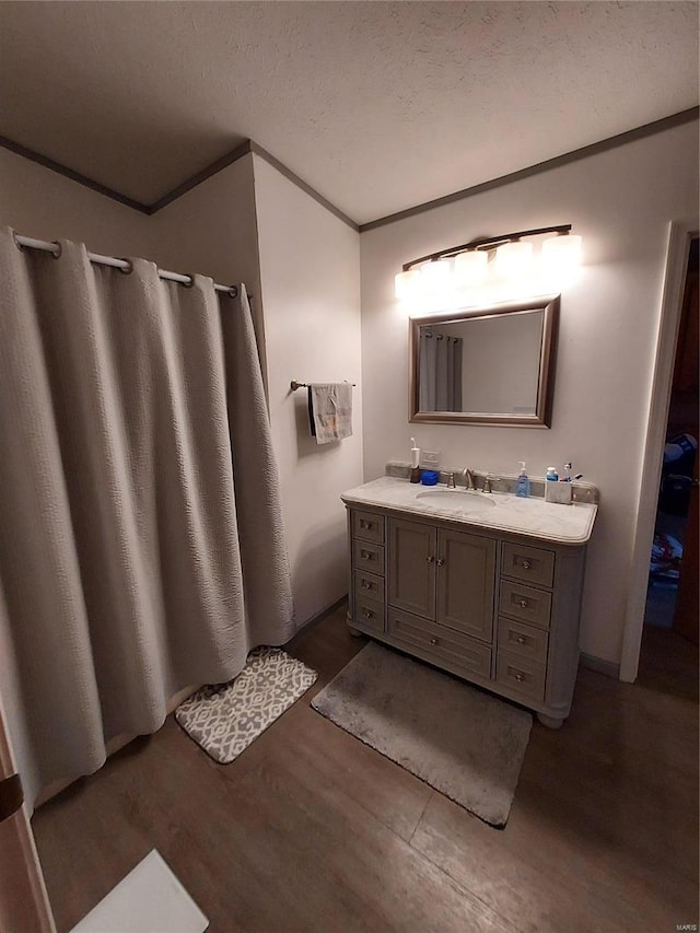 bathroom with hardwood / wood-style flooring, vanity, and a textured ceiling