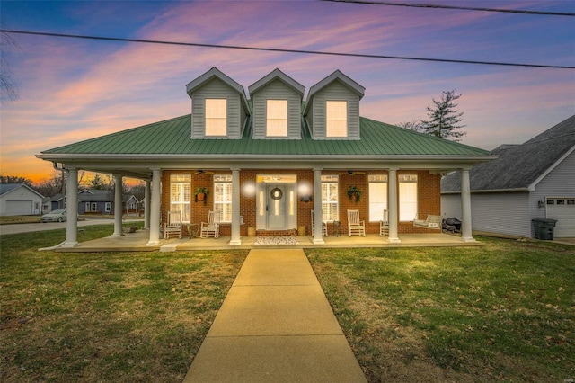 view of front of property featuring covered porch and a yard