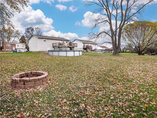 view of yard with a swimming pool side deck and an outdoor fire pit