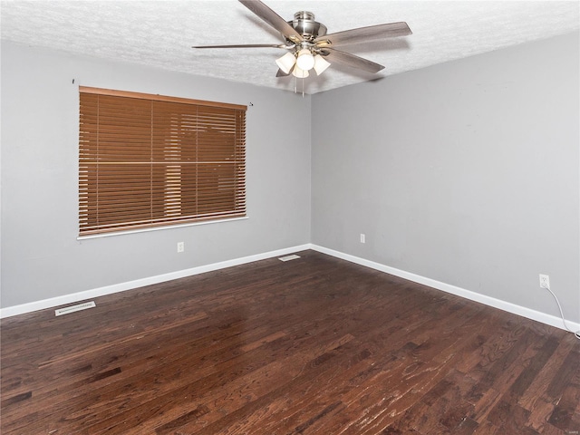 spare room featuring dark hardwood / wood-style floors, ceiling fan, and a textured ceiling