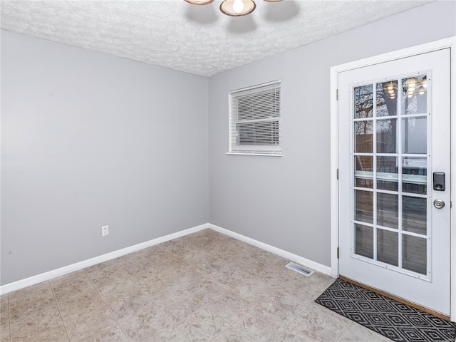 unfurnished room with a textured ceiling