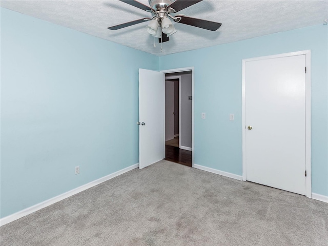 unfurnished bedroom featuring a textured ceiling, light colored carpet, and ceiling fan