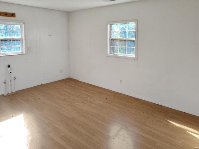 spare room featuring light hardwood / wood-style floors and a healthy amount of sunlight