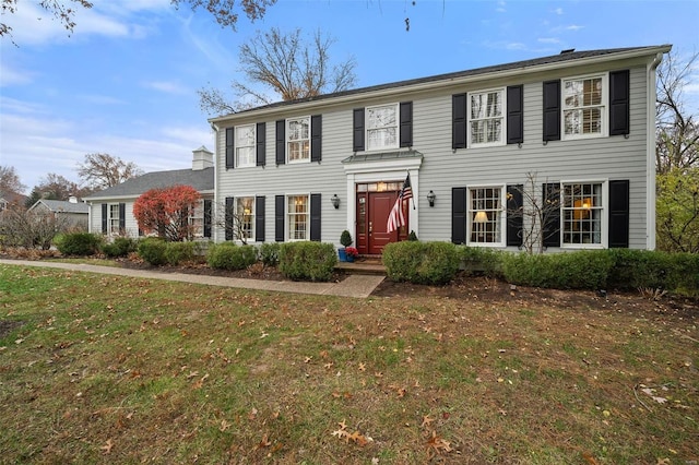 colonial-style house with a front lawn