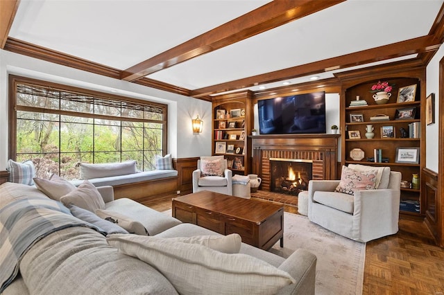 living room with beam ceiling, a brick fireplace, parquet floors, and crown molding