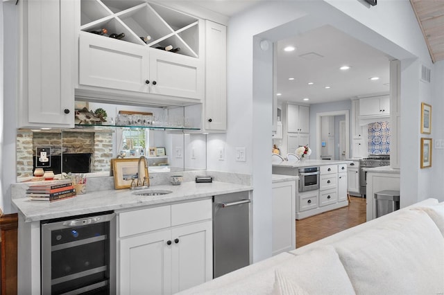 kitchen with white cabinetry, sink, wine cooler, and stainless steel appliances