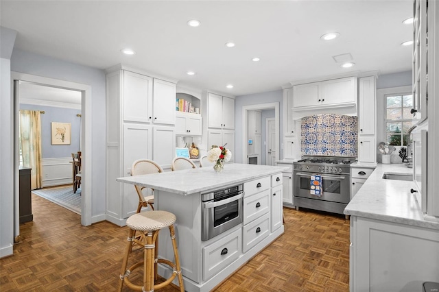 kitchen featuring a breakfast bar area, a center island, white cabinets, and stainless steel appliances