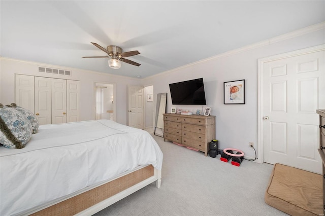 carpeted bedroom with a closet, ceiling fan, and ornamental molding