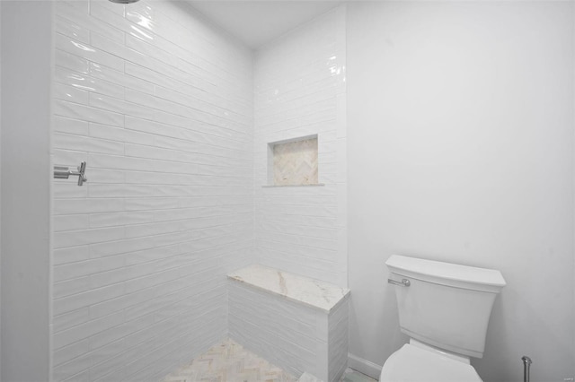 bathroom featuring toilet and tiled shower